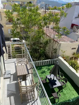 a balcony with a wooden table and chairs and a table at Άγιος Ιωάννης in Chania Town