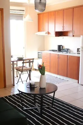 a living room with a table and a kitchen at Down Town apartment 27a in Chania Town