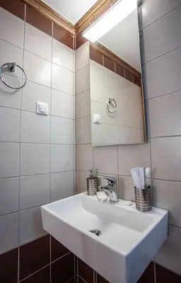 a bathroom with a white sink and a mirror at Chania Paradise Retreat in Rodhopós