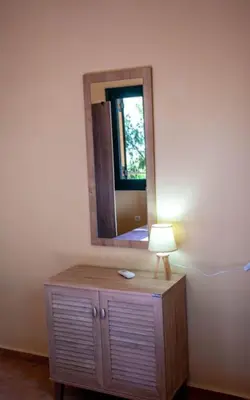 a lamp on a dresser in a room with a mirror at Chania Paradise Retreat in Rodhopós