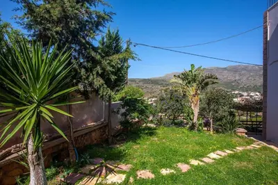 a garden with palm trees and a building at Chania Paradise Retreat in Rodhopós