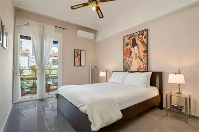 a bedroom with a large bed with a ceiling fan at Modern & Spacious Flat - Chania Center - Walk To Sea in Chania Town