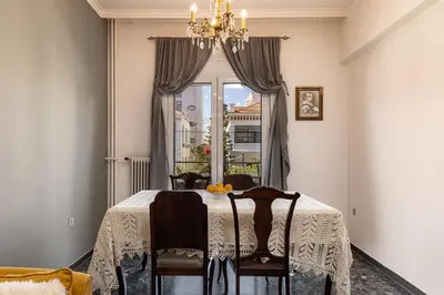 a dining room with a table with chairs and a window at Modern & Spacious Flat - Chania Center - Walk To Sea in Chania Town