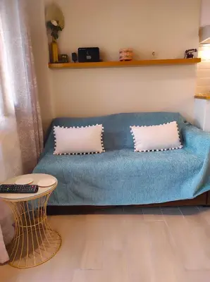 a blue couch with two pillows in a living room at Ploumi in Chania Town