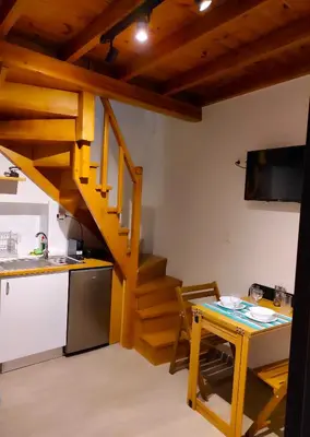 a kitchen with a table and a staircase in a room at Ploumi in Chania Town