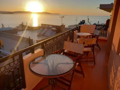 a balcony with a table and chairs and the sunset at Villa Nancy in Chania Town