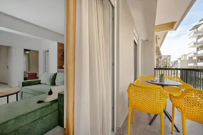 a room with a balcony with a table and chairs at Luxury Chic Retreat Suites in Chania Town