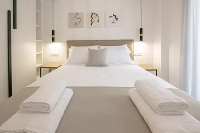 a bedroom with a large white bed with towels on it at Luxury Chic Retreat Suites in Chania Town
