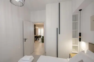 a white bedroom with a bed and a dining room at Luxury Chic Retreat Suites in Chania Town