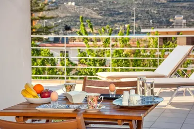 a table with fruit on top of a balcony at Sea Stars Cozy Suite in Souda