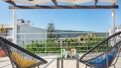 a balcony with two chairs and a table on a roof at Sea Stars Cozy Suite in Souda
