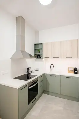 a kitchen with white cabinets and a stove top oven at Boho Chic Retreat Suite in Chania Town