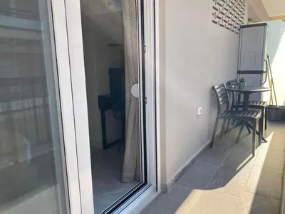 a sliding glass door to a balcony with a table at Boho Chic Retreat Suite in Chania Town