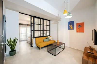 a living room with a yellow couch and a table at Boho Chic Retreat Suite in Chania Town