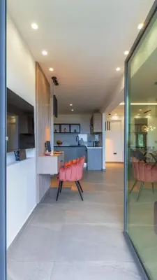 a living room with red chairs and a kitchen at Seascape Luxury Apartment in Kounoupidhianá