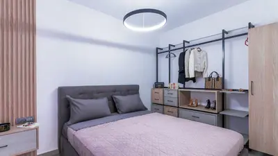 a bedroom with a bed with a dresser and a closet at Seascape Luxury Apartment in Kounoupidhianá