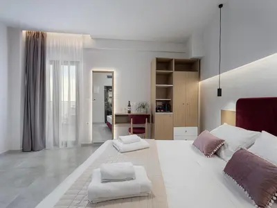 a bedroom with a large white bed with two pillows at Miss Marrone City Hotel in Chania Town