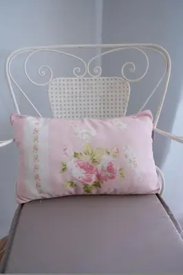a white chair with a pink pillow on it at Natalia's Apartment in Tavronitis in Tavronitis