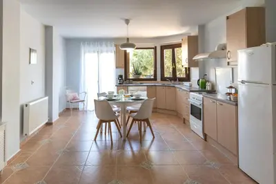 a kitchen with a table and chairs and a refrigerator at Natalia's Apartment in Tavronitis in Tavronitis