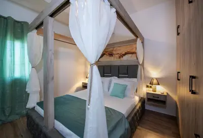 a bedroom with a four poster bed with a canopy at 7thHeaven Luxury aprts in Chania Town