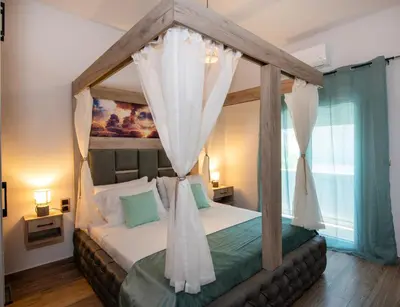 a bedroom with a canopy bed with white curtains at 7thHeaven Luxury aprts in Chania Town