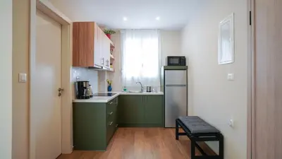 a small kitchen with green cabinets and a window at Odyssey Residences 2 in Chania Town