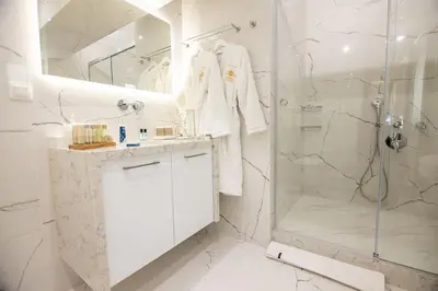 a white bathroom with a shower and a sink at Nobel apartment, Chania Town in Chania Town