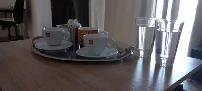 a tray with cups and glasses on a wooden table at Emmanuel apartment in Agia Marina Nea Kydonias