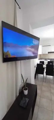 a living room with a large flat screen tv on a wall at Emmanuel apartment in Agia Marina Nea Kydonias