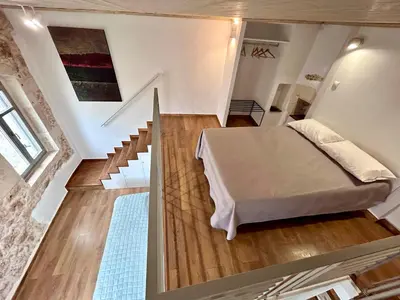 a bedroom with a bed and a staircase in a room at Kazalakis Chania Harbor Roof top retreat in Chania Town