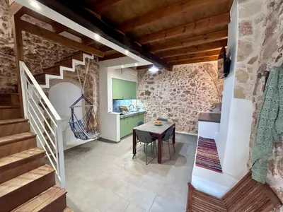 a kitchen and dining room with stairs and a table at Kazalakis Chania Harbor Roof top retreat in Chania Town