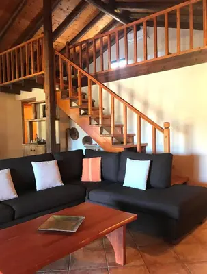a living room with a black couch and wooden stairs at Impressive Platanias Villa Villa Bulma 2 Bedrooms Private Pool in Plataniás