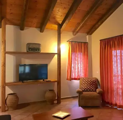 a living room with a tv and a chair at Impressive Platanias Villa Villa Bulma 2 Bedrooms Private Pool in Plataniás