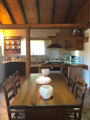 a kitchen with a wooden table with chairs and a kitchen with a counter at Impressive Platanias Villa Villa Bulma 2 Bedrooms Private Pool in Plataniás