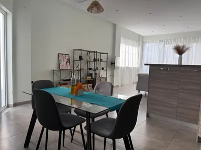 a dining room with a blue table and chairs at Karamela Apartment in Kambánion
