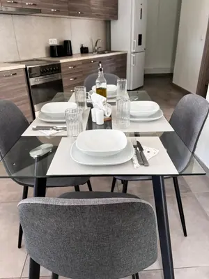 a dining room table with chairs and white plates at Karamela Apartment in Kambánion
