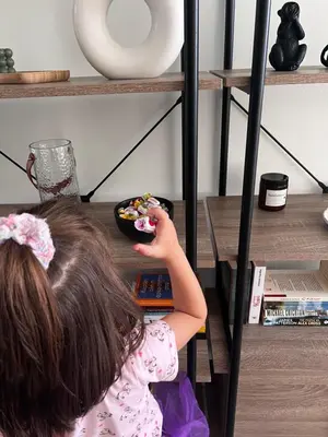 a little girl eating food in a bowl on a shelf at Karamela Apartment in Kambánion