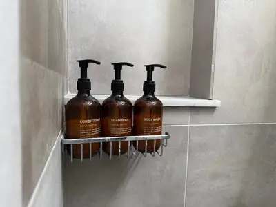 three bottles of alcohol sitting on a shelf in a bathroom at Karamela Apartment in Kambánion