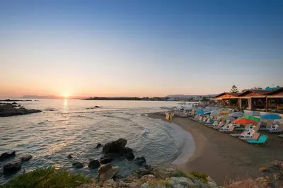 a beach with a group of umbrellas and chairs at The Blue Studio, 1 min walk from Kalamaki beach in Kalamaki Chanion
