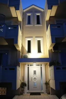 a large white building with a white door at The Blue Studio, 1 min walk from Kalamaki beach in Kalamaki Chanion