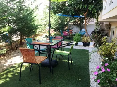 a table and chairs with an umbrella on a lawn at The Blue Studio, 1 min walk from Kalamaki beach in Kalamaki Chanion