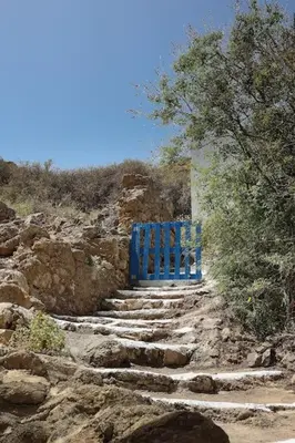 a blue bench sitting on the side of a mountain at Fortezza studio in Palaiochóra