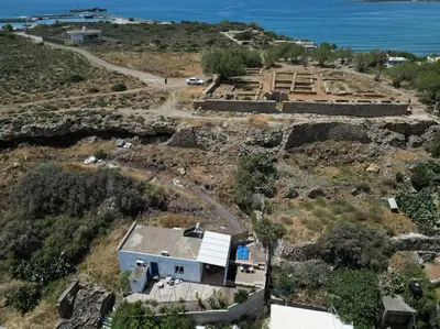 an aerial view of a house on a hill next to the ocean at Fortezza studio in Palaiochóra