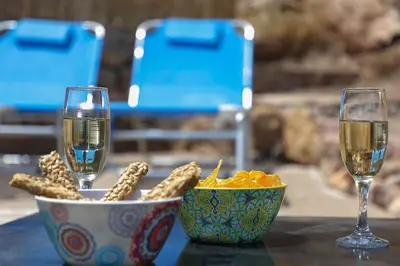a table with two glasses of wine and a bowl of popcorn at Fortezza studio in Palaiochóra
