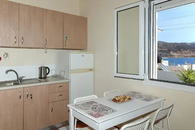 a kitchen with a table and a sink and a window at Fortezza studio in Palaiochóra