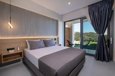 a bedroom with a bed and a large window at Arithea Villa in Chania Town