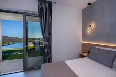 a bedroom with a bed and a large window at Arithea Villa in Chania Town