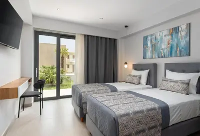 a hotel room with two beds and a television at LUXURY VILLA EOS Beachfront 20 metres from the sea in Nopíyia