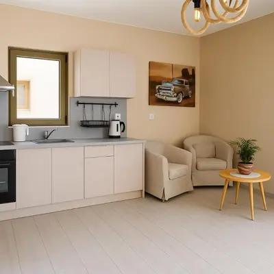 a kitchen with white cabinets and a couch and a table at Paliochora Beachfront Escape, Milolithos Pool Retreats in Palaiochóra