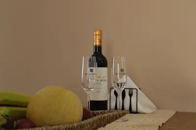 a bottle of wine and two wine glasses on a table at Paliochora Beachfront Escape, Milolithos Pool Retreats in Palaiochóra